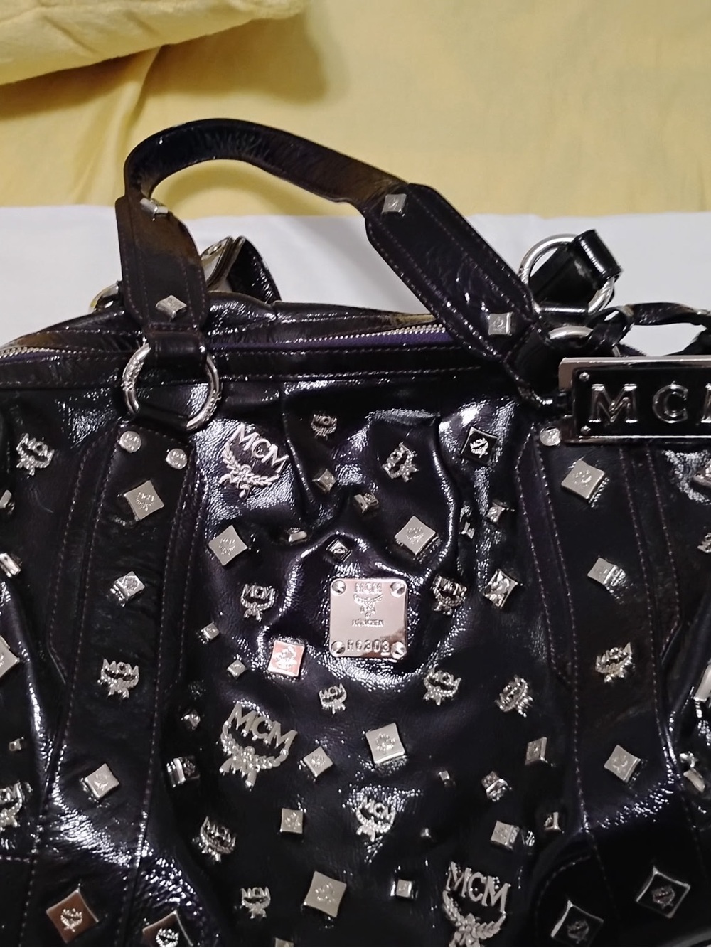 MCM Purple Black Studded Patent Leather Satchel with purple tassel.